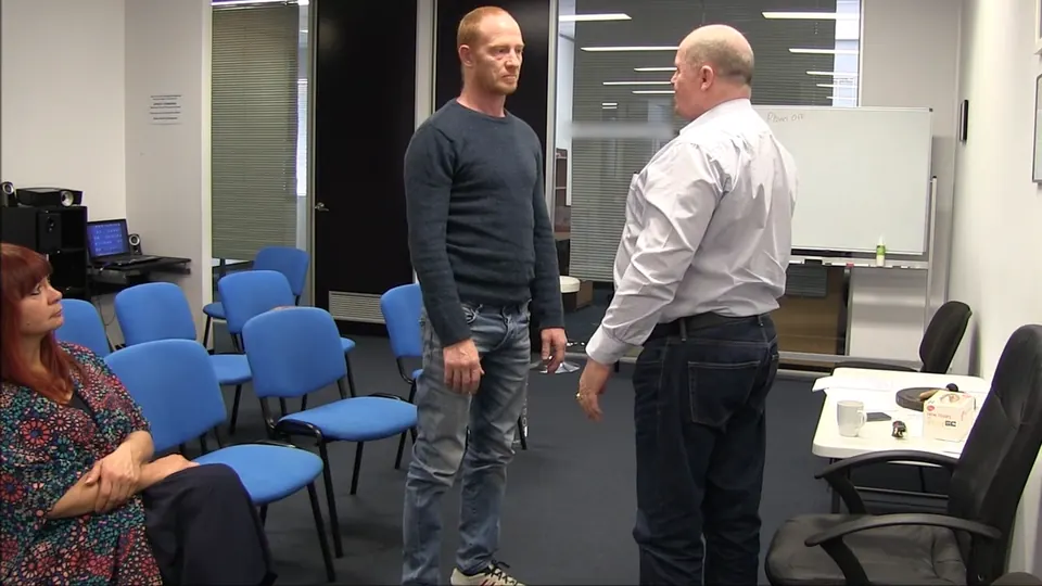 Rick Collingwood standing face to face with a male student in the middle of a training room
