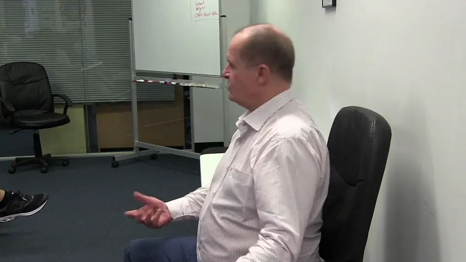 Rick Collingwood seated and gesturing as he teaches a small group