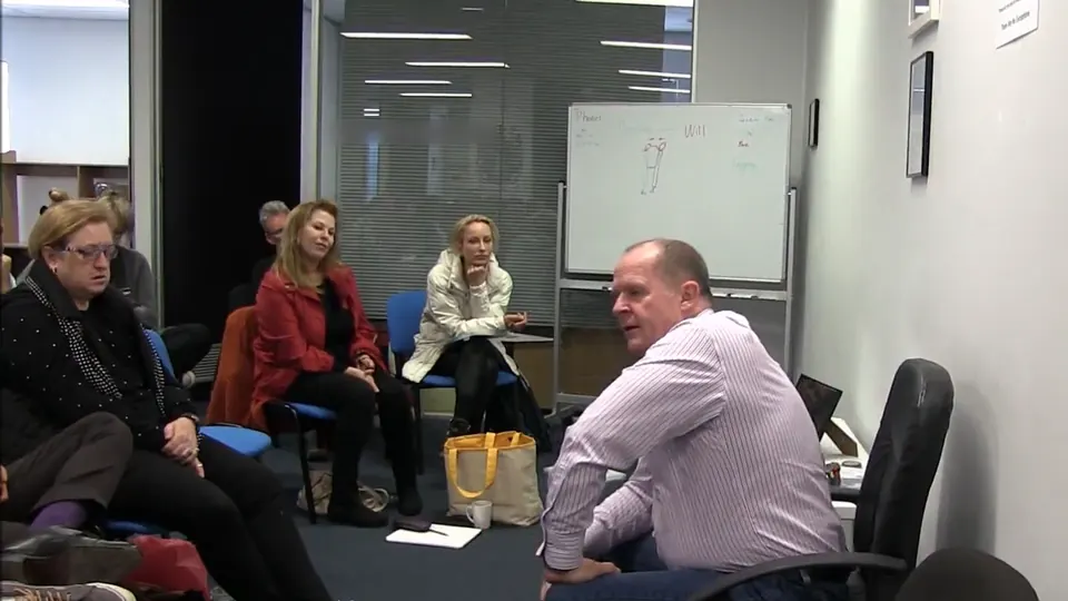 Rick Collingwood turning in his chair to speak with students seated around the room