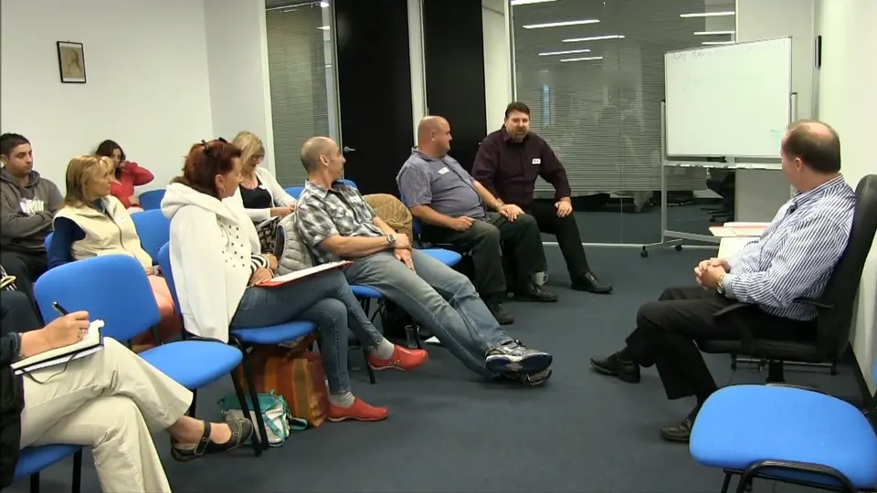 Rick Collingwood seated facing a class of students in a training room