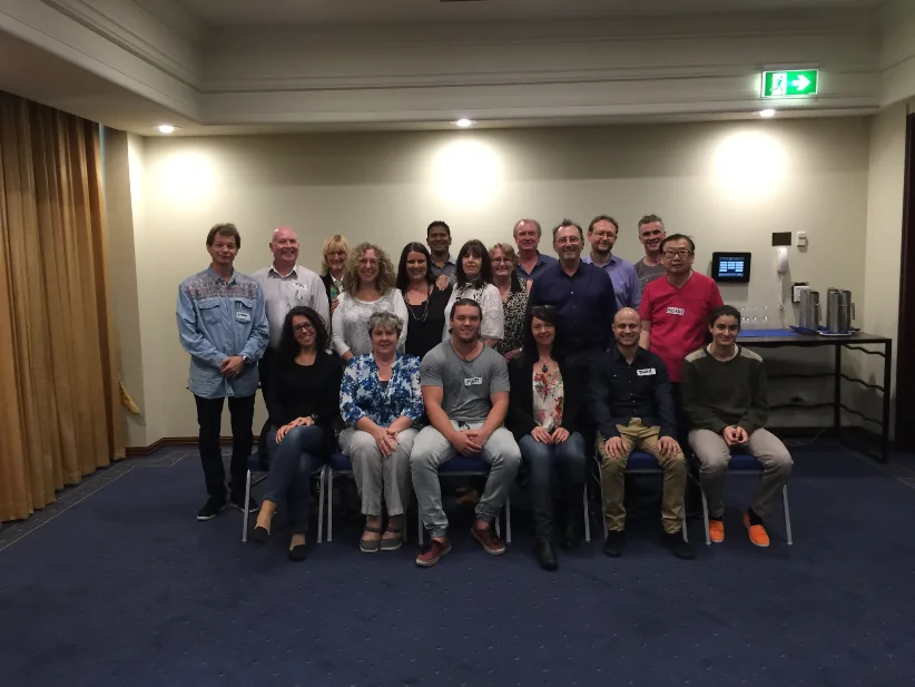 A seated and standing Global Hypnosis Academy class photographed in the training room